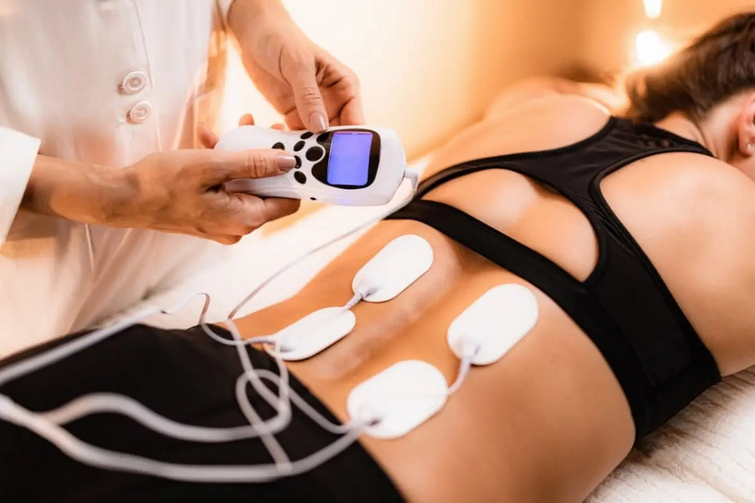 A woman is using a TENS unit for pain relief.